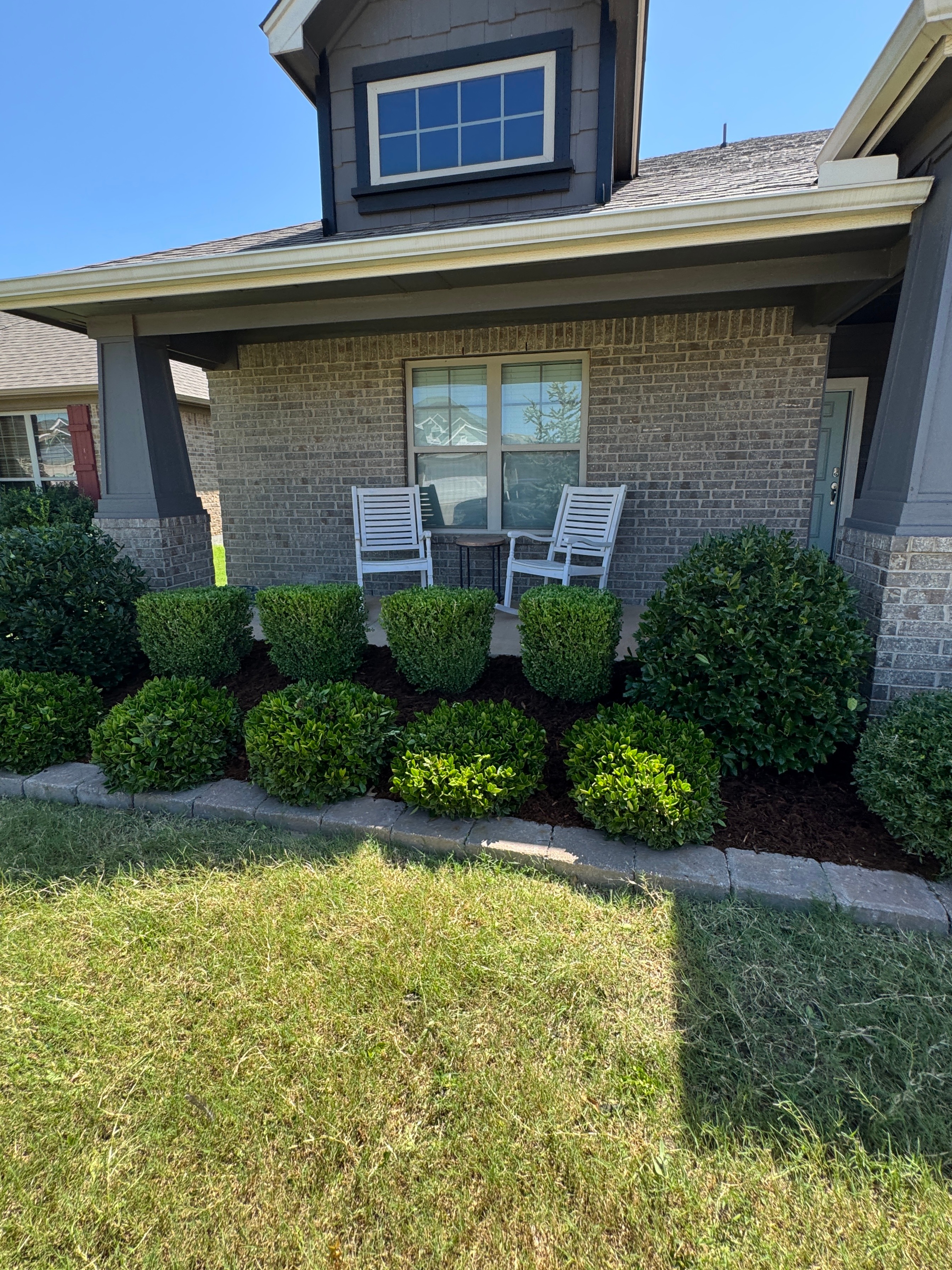 Professionally designed colorful flower bed with perennials and ornamental plants in an Oklahoma front yard